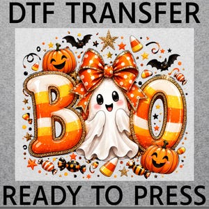 May include: A DTF transfer sheet featuring the text DTF TRANSFER READY TO PRESS. The graphic shows a white ghost wearing a large orange polka-dot bow, flanked by the letters BOO in candy corn colors, jack-o'-lanterns, bats, and candy.