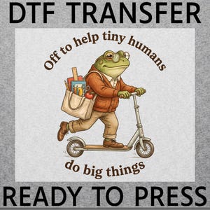 May include: A DTF transfer featuring a green frog wearing glasses, a brown cardigan, and tan trousers, riding a silver scooter. The frog carries a beige tote bag filled with school supplies. Text reads: DTF TRANSFER, Off to help tiny humans, do big things, READY TO PRESS.