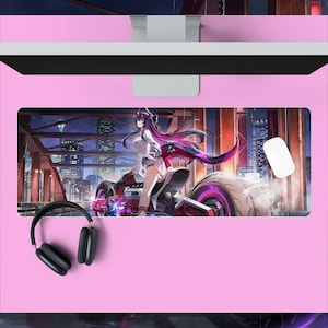May include: A rectangular desk mat featuring an anime-style illustration of a character with long dark hair riding a futuristic red motorcycle on a bridge at night. The mat is placed on a pink desk surface with black over-ear headphones and a white mouse.