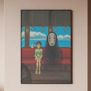 May include: Framed art print featuring a scene from an animated film. The artwork depicts two figures seated on a red bench inside a train car, with a blue sky and ocean visible through the windows. The figures include a young person and a tall, dark figure.