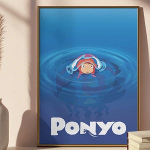 Pu&ograve; includere: Una stampa artistica incorniciata con il personaggio animato Ponyo in una scena acquatica blu. L'opera mostra Ponyo con i capelli rossi e un copricapo bianco e blu, con la parola "PONYO" in lettere bianche in basso.