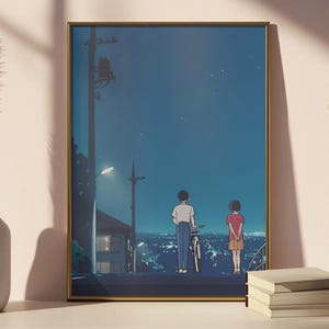 Może przedstawiać: Oprawiony wydruk artystyczny z ilustracją w stylu anime przedstawiającą dwie postacie na wzg&oacute;rzu z widokiem na miasto nocą. Grafika ma złotą ramę i przedstawia chłopca z rowerem i dziewczynkę. Niebo jest ciemnoniebieskie z gwiazdami.