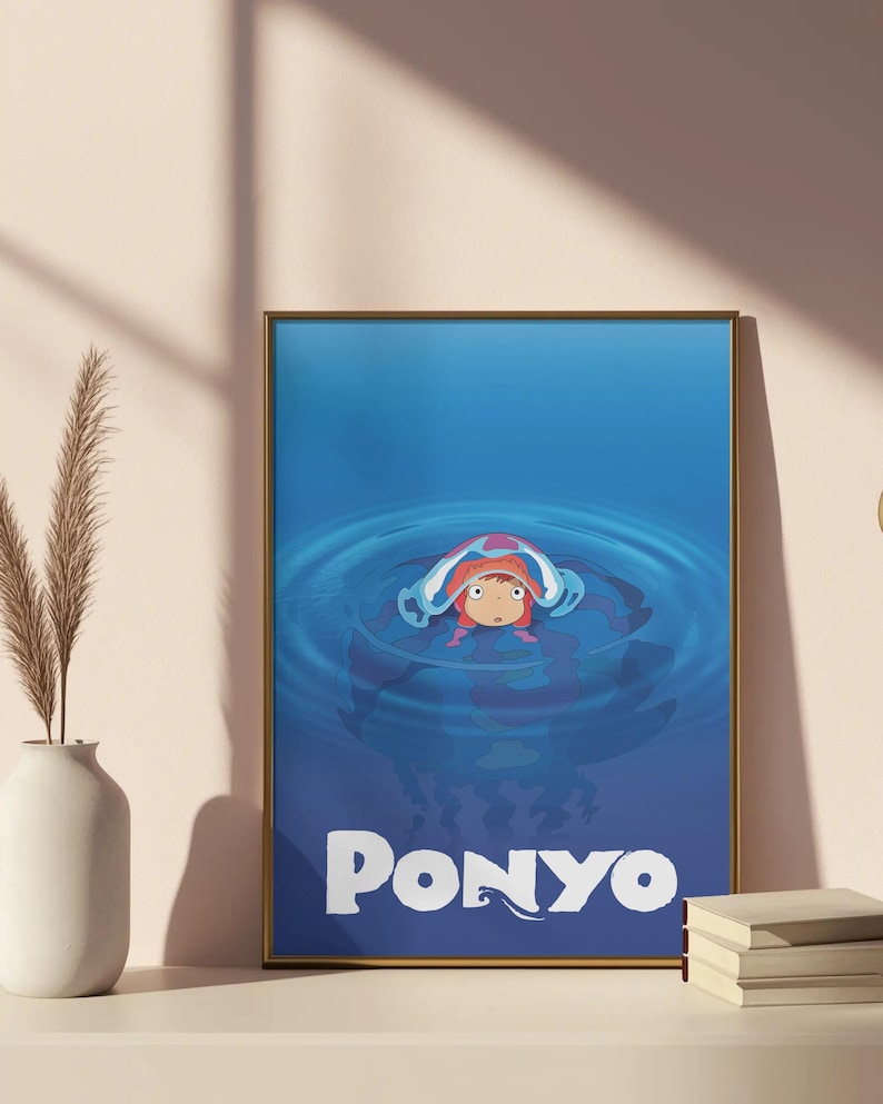 Pu&ograve; includere: Una stampa artistica incorniciata con il personaggio animato Ponyo in una scena acquatica blu. L'opera mostra Ponyo con i capelli rossi e un copricapo bianco e blu, con la parola "PONYO" in lettere bianche in basso.