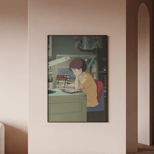Peut inclure: &OElig;uvre d'art encadr&eacute;e de style anime repr&eacute;sentant une personne en chemise jaune assise &agrave; un bureau, absorb&eacute;e par l'&eacute;criture. La sc&egrave;ne est &eacute;clair&eacute;e par une lampe de bureau, avec des livres et une chaise rouge. L'&oelig;uvre est plac&eacute;e contre un mur neutre.