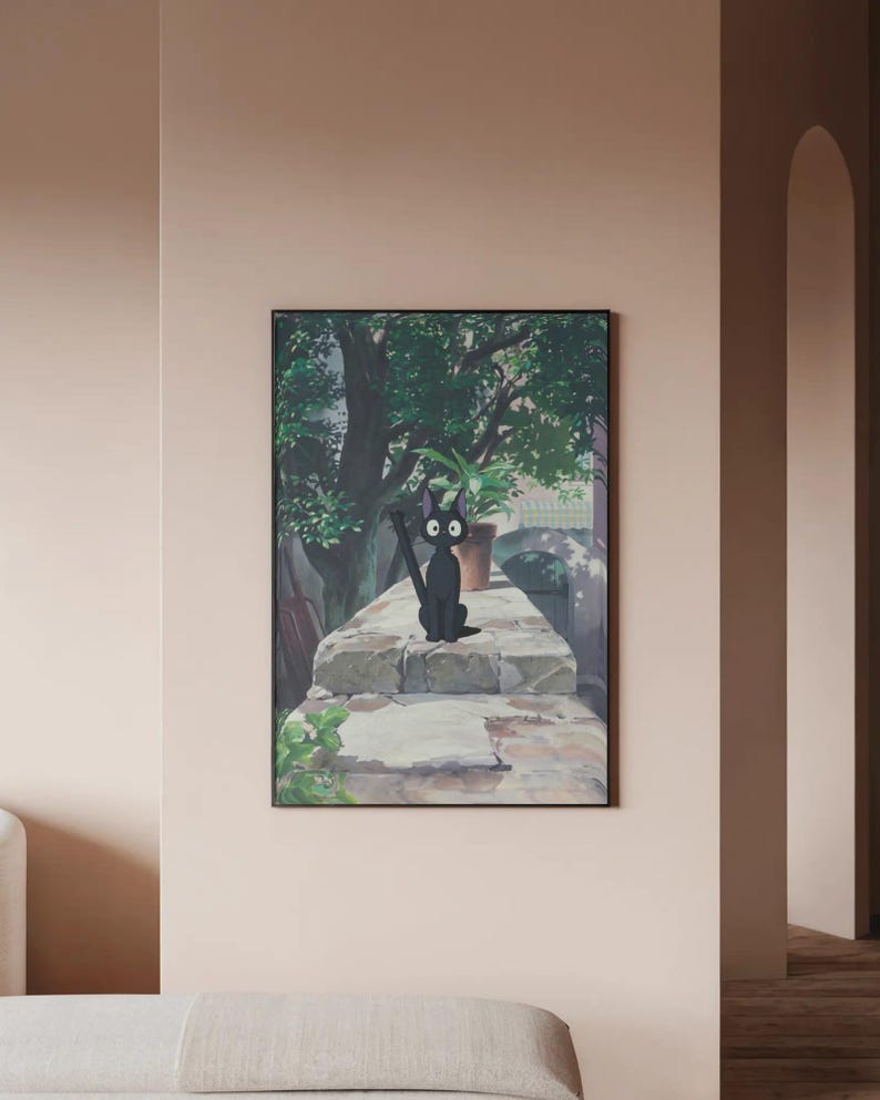 May include: Framed art print featuring a black cat with large eyes, sitting on a stone wall. The background shows a lush green tree and a potted plant. The artwork has a whimsical, cartoon-like style.