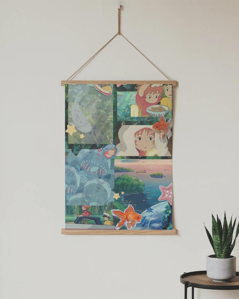 May include: A poster featuring a collage of animated scenes, including a goldfish, a girl with red hair, and various landscapes. The poster is held by wooden bars and suspended by a string, creating a decorative wall hanging.