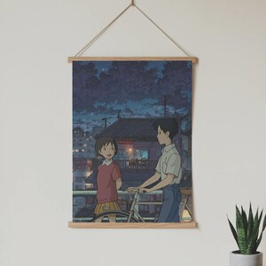 Pode incluir: Um poster com uma ilustra&ccedil;&atilde;o em estilo anime de um rapaz e uma rapariga numa varanda &agrave; noite. O rapaz est&aacute; a segurar uma bicicleta. O poster &eacute; montado numa moldura de madeira e suspenso por uma corda.