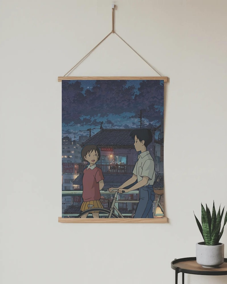 Pode incluir: Um poster com uma ilustra&ccedil;&atilde;o em estilo anime de um rapaz e uma rapariga numa varanda &agrave; noite. O rapaz est&aacute; a segurar uma bicicleta. O poster &eacute; montado numa moldura de madeira e suspenso por uma corda.