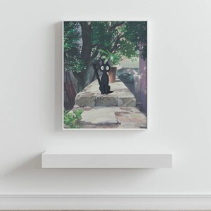May include: A framed print featuring a black cat with large eyes, sitting on a stone wall. The cat is holding a broom. A potted plant and lush greenery are in the background, with a soft, natural light.