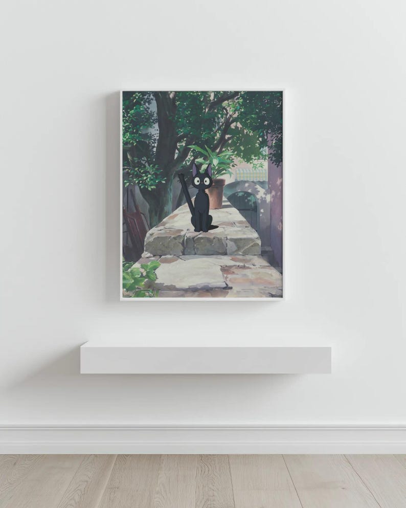 May include: A framed print featuring a black cat with large eyes, sitting on a stone wall. The cat is holding a broom. A potted plant and lush greenery are in the background, with a soft, natural light.
