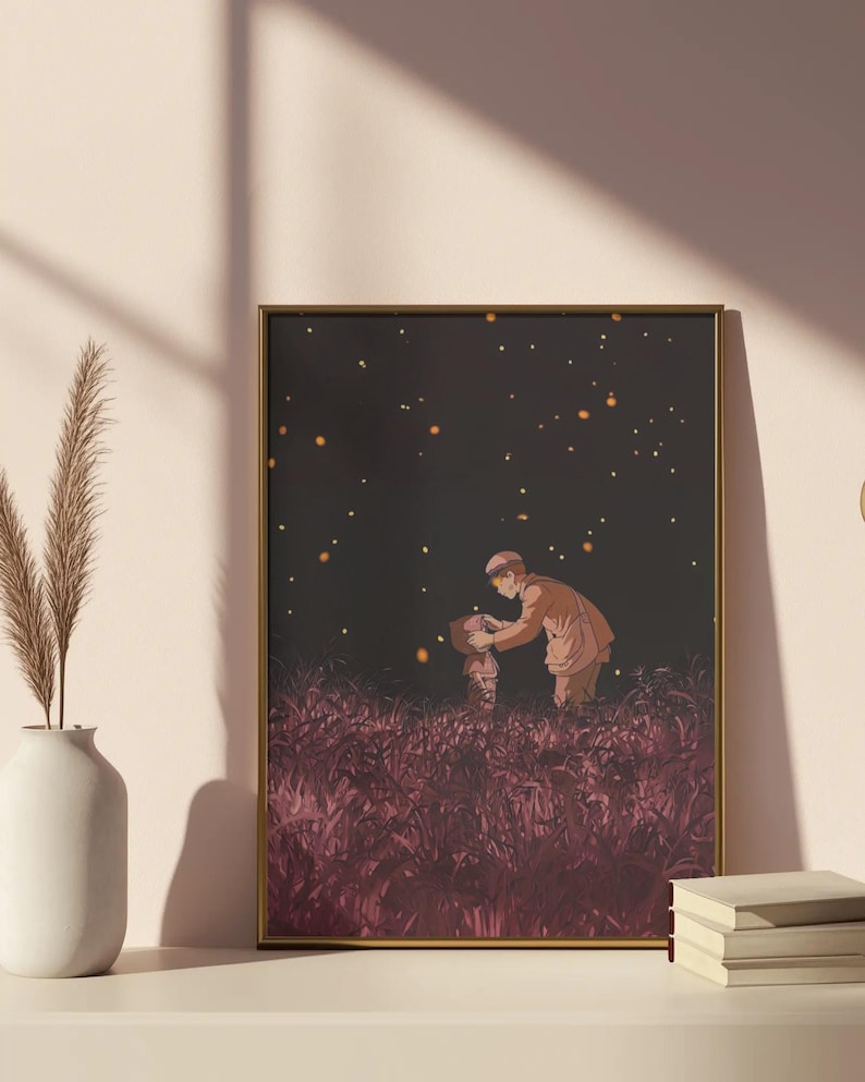 May include: A framed art print featuring an illustration of two figures in a field of tall, red grass under a dark sky with glowing orbs. The figures are dressed in warm-toned clothing, with a gold frame.