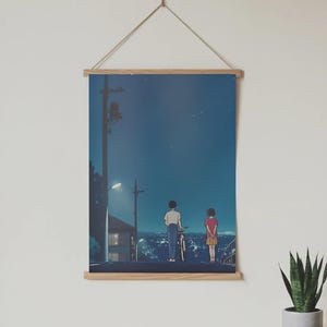 Może przedstawiać: Plakat z ilustracją w stylu anime przedstawiającą dwie postacie stojące na drodze w nocy, z rowerem. Tło przedstawia krajobraz miejski pod gwiaździstym niebem, z latarnią uliczną i liniami energetycznymi.