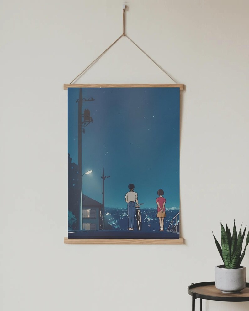 Może przedstawiać: Plakat z ilustracją w stylu anime przedstawiającą dwie postacie stojące na drodze w nocy, z rowerem. Tło przedstawia krajobraz miejski pod gwiaździstym niebem, z latarnią uliczną i liniami energetycznymi.