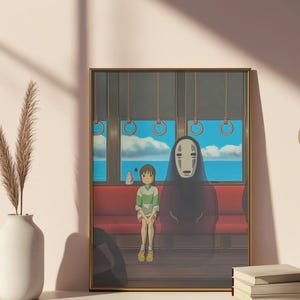 May include: Framed art print featuring a scene from an animated film. A young person in a green and white striped shirt sits on a red bench next to a tall, cloaked figure with a white mask. The background shows a seascape through train windows.
