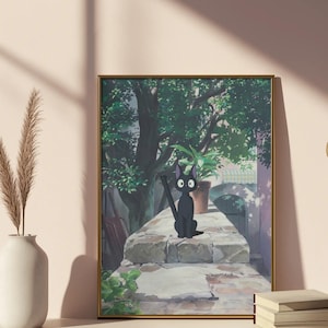 May include: Framed art print featuring a black cat with large eyes, sitting on a stone wall. The background shows a lush green tree, a potted plant, and a glimpse of a building. The artwork is in a gold frame and rests on a white surface.