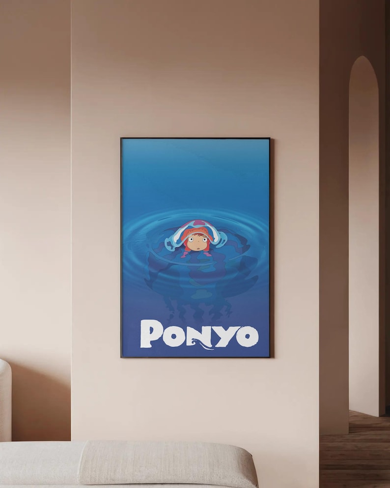 Pu&ograve; includere: Poster incorniciato con la parola "Ponyo" in testo bianco, raffigurante un personaggio animato nell'acqua. Il personaggio ha i capelli rossi ed &egrave; circondato da acqua blu. Il poster &egrave; in una cornice nera ed &egrave; appeso a un muro beige.