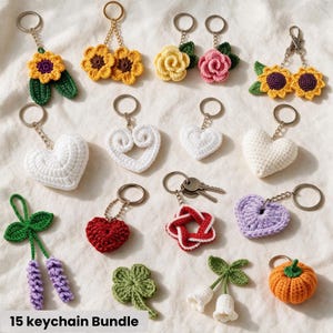 Pode incluir: Um conjunto de 15 porta-chaves de croché com vários designs, incluindo girassóis, rosas, corações, um trevo de quatro folhas, uma abóbora, alfazema e flores brancas em forma de sino, cada um preso a um anel de metal prateado.