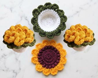May include: Handmade crochet coasters and decorative pieces. The image features a sunflower coaster with a deep purple center and yellow petals, along with three flower-shaped coasters in yellow and green. One coaster is a bowl shape with a white interior.