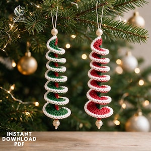 May include: Two spiral-shaped crochet ornaments hanging from strings. One ornament features green yarn with white trim, and the other features red yarn with white trim. Each piece is topped and finished with a small, round, cream-colored bead.
