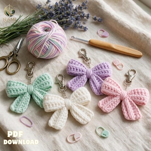 May include: Four crocheted bow keychains in mint green, white, lavender, and light pink, each with a silver metal lobster clasp. A ball of variegated pastel yarn, a wooden crochet hook, metal scissors, and small plastic stitch markers are included.
