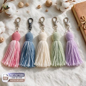 Puede incluir: Cinco llaveros de borlas de ganchillo hechos a mano en rosa, azul, crema, verde salvia y lavanda. Cada llavero cuenta con una cabeza redonda tejida a ganchillo unida a un mosquetón de metal plateado, con largos flecos de hilo de algodón.