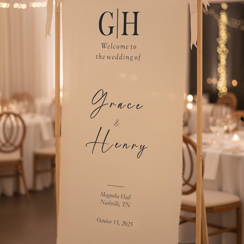 Puede incluir: Un cartel de bienvenida de boda color crema con las iniciales "GH" en la parte superior. El cartel dice "Bienvenida a la boda de Grace & Henry" e incluye el lugar y la fecha: Magnolia Hall, Nashville, TN, 15 de octubre de 2025.