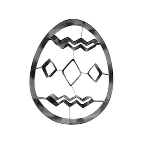 Puede incluir: Cortador de galletas de metal con forma de huevo de Pascua. El cortador presenta un diseño decorativo con zigzags y rombos dentro del contorno del huevo. Hecho de metal plateado.