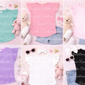 Puede incluir: Colección de seis camisetas infantiles en varios colores: verde menta, rosa, rosa claro, morado, blanco y negro. Cada camiseta tiene mangas con volantes y se combina con pantalones cortos de mezclilla, gafas de sol y accesorios. Las camisetas se exhiben con juguetes y zapatos.