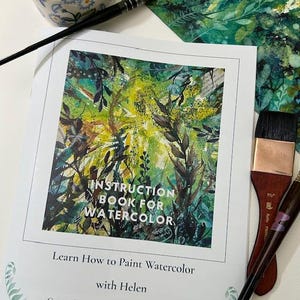 以下が含まれることがあります： 「Instruction Book for Watercolor」というタイトルの水彩画の指導書。 「Learn How to Paint Watercolor with Helen」というテキスト。ブラシと、花柄の陶器の容器が写っています。