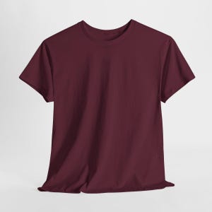 Puede incluir: Una camiseta lisa de color burdeos con cuello redondo. La camiseta de manga corta est&aacute; hecha de un material suave y se muestra sobre un fondo blanco. Un b&aacute;sico de armario.