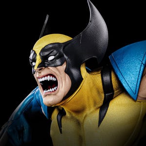 May include: A detailed bust of Wolverine, a comic book character, with a fierce expression. The figure features a yellow and blue costume, a black mask, and prominent claws. The character's mouth is open, revealing teeth.