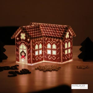 Könnte beinhalten: Ein dekoratives, beleuchtetes Lebkuchenhaus aus roten und weißen Perlen. Das Haus hat ein detailliertes Dach, Fenster und eine Tür mit einem Kranz. Das Innere ist beleuchtet und erzeugt einen warmen Schein. Ein Schneeflocke und Text sind ebenfalls sichtbar.