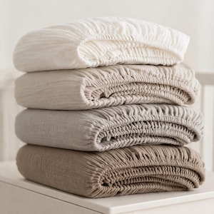 May include: A white ceramic mug with a black handle and the text "But First, Coffee" in a handwritten style. The mug is on a white surface. The mug is approximately 4 inches tall.