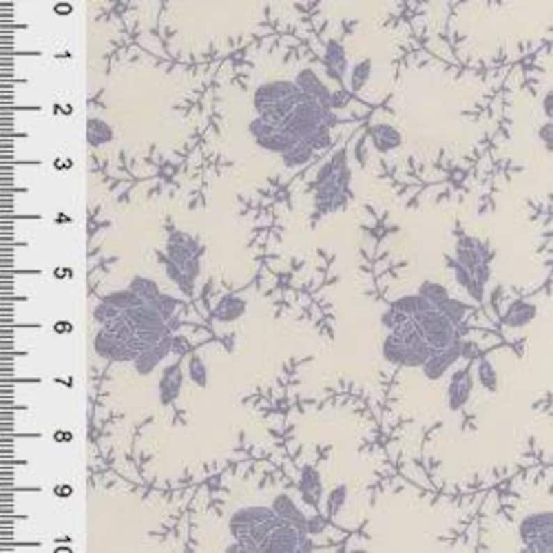 May include: Cream-colored fabric with a repeating pattern of lavender roses and vines. The design includes detailed floral elements and delicate foliage, creating a vintage aesthetic. The fabric is measured in inches.