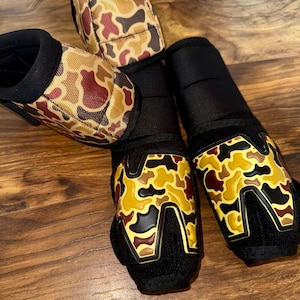 May include: A white ceramic mug with a black handle and the text "But First, Coffee" in a black, handwritten-style font. The mug is on a white surface.