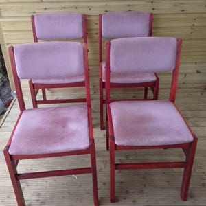 Op de afbeelding: Vier vintage stoelen met een rood gebeitst houten frame en lichtroze gestoffeerde zittingen en rugleuningen. De stoelen zijn in een groep gerangschikt, waarbij hun ontwerp wordt benadrukt. Geschikt voor een eetkamer of woonkamer, elke stoel is ongeveer 45 cm breed.