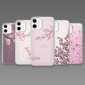 May include: Five phone cases with floral designs. The cases display pink cherry blossom branches and flowers on white, pink, and purple backgrounds. One case has the Japanese word "sakura" printed on it. The cases are designed for a mobile phone.