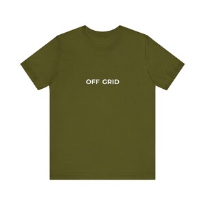 Op de afbeelding: Olijfgroen t-shirt met de witte tekst "OFF GRID" op de borst. Het t-shirt heeft korte mouwen en een ronde hals. De stof lijkt zacht en licht van gewicht. Een casual kledingstuk.