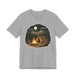 Könnte beinhalten: Graues T-Shirt mit einer Camping-Szene. Die Grafik zeigt ein Zelt, ein Lagerfeuer, Berge und einen Vollmond unter einem Sternenhimmel. Das Design umfasst Bäume, eine Axt und einen Rucksack, was ein Naturthema suggeriert.