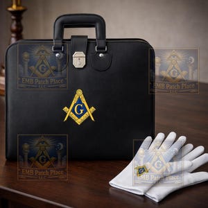 May include: A black leather briefcase with a handle and silver hardware, featuring a Masonic emblem. Beside it are a pair of white gloves, also displaying the emblem. The briefcase has the text "EMB Patch Place LLC".