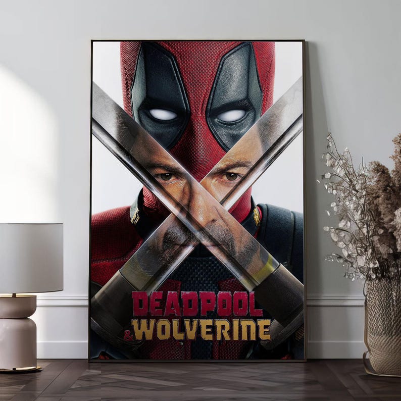 K&ouml;nnte beinhalten: Gerahmtes Poster mit Deadpool und Wolverine. Das Bild zeigt Deadpools Maske und gekreuzte Schwerter, mit Wolverines Gesicht teilweise sichtbar. Der Titel "DEADPOOL & WOLVERINE" ist in Rot und Gold dargestellt.