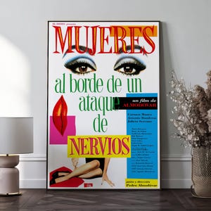May include: A framed movie poster for "Women on the Verge of a Nervous Breakdown." The poster features the title in red, stylized eyes, and the film's title in Spanish. The poster has a colorful design with a woman's legs and a red lip.