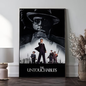 Puede incluir: Un póster de película en blanco y negro enmarcado para "Los Intocables". El póster presenta una imagen grande de un hombre con sombrero y gafas de sol, con otros hombres con trajes y sombreros en primer plano. El título está en la parte inferior.