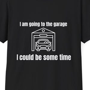 May include: Black t-shirt with white text and a graphic of a car in a garage. The text reads "I am going to the garage, I could be some time."