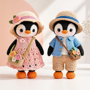 Puede incluir: Dos muñecos de pingüino de ganchillo. Uno con vestido rosa y sombrero, el otro con camisa azul, pantalones cortos y sombrero. Ambos tienen pies naranjas y bolsos con flores. Hecho a mano.