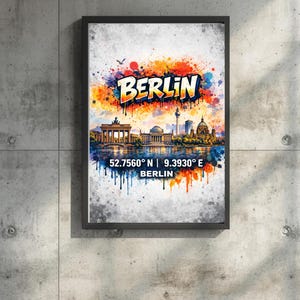 Op de afbeelding: Een ingelijste kunstdruk met een kleurrijke aquarel illustratie van de skyline van Berlijn. Het woord "BERLIJN" wordt in vette, gestileerde letters boven de skyline weergegeven. Coördinaten en de naam van de stad staan eronder.