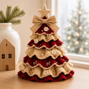 May include: A tiered crochet Christmas tree decoration featuring alternating layers of deep red and cream yarn. The tree is topped with a crocheted star and a beige ribbon bow, and is embellished with small white floral accents and pearl beads.