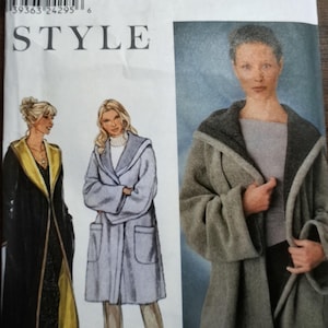 May include: A Simplicity sewing pattern envelope 9401 featuring illustrations and a photograph of a hooded coat. The pattern includes size options XS, S, M, L, and XL. The designs show a long black coat with a yellow lining and a shorter light blue coat.