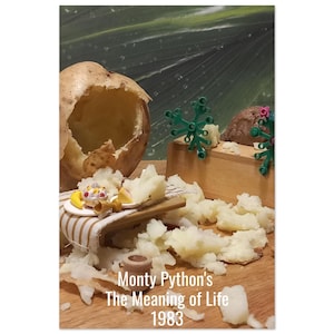 May include: A quirky still life with a large, hollowed-out potato, miniature food, and scattered mashed potato. There's a small wooden box and green plastic decorations. The image includes the text "Monty Python's The Meaning of Life 1983."