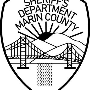May include: Black and white Marin County Sheriff's Department badge. The badge features the text "SHERIFF'S DEPARTMENT MARIN COUNTY" in a curved font. A bridge, mountains, sun, and water are depicted in the center.